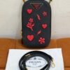 Pre-Owned/ Pre-Loved/ Second-Hand Prada Phone and Card Crossbody Carrier, Bag in Black, Red Charms, Gold Hardware Color, 10 x 18 x 2 cm Size, Front View